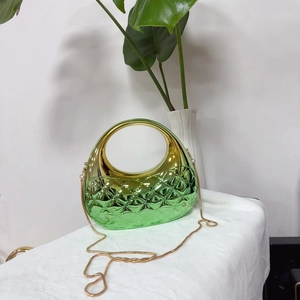 Détail macro de l'embrayage en acrylique nuage avec dégradé vert doré et texture matelassée