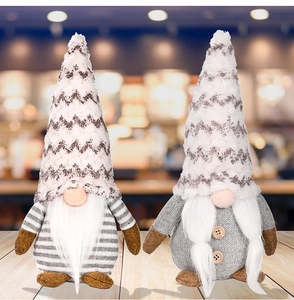 Detail of two Christmas gnomes with grey knit hats and long white beards on wood