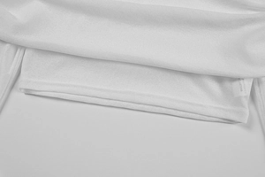 Dettaglio dell'orlo a doppio strato e trama del tessuto su un crop top bianco aderente