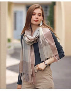 Close-up of soft cashmere-like scarf with pink and grey plaid pattern and tassel fringe