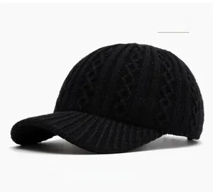 Macro shot of black knitted baseball cap showing textured diamond and ribbed stitch patterns