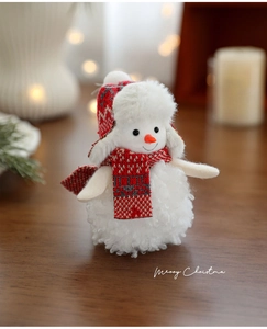 Detailed view of a soft plush snowman ornament with red and white knit scarf and hat