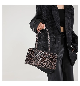 Fashionable leopard print shoulder bag featuring a heart charm and animal fur texture