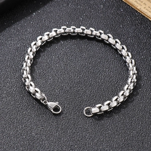 Polished silver stainless steel chain bracelet with lobster clasp on black background