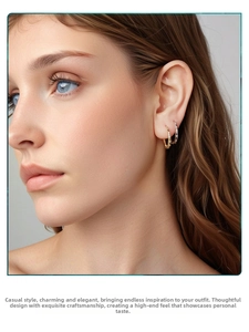 Close-up of model wearing S925 sterling silver hoop earrings with star engravings