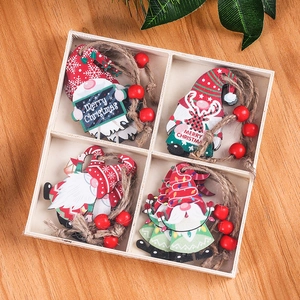 Detail of four wooden Christmas gnome ornaments with Merry Christmas text in a wood box