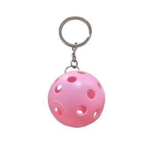 Close-up of pink plastic pickleball keychain with hollow holes and a metal ring