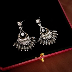 Macro detail of fan-shaped fringe earrings with crystal rhinestones in jewelry box