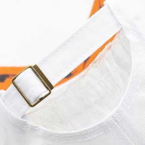 Detailed close-up of white baseball cap showing adjustable metal buckle and neat stitching