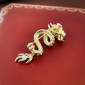 Golden dragon brooch with zodiac motif showing detailed rear view on a luxury red background