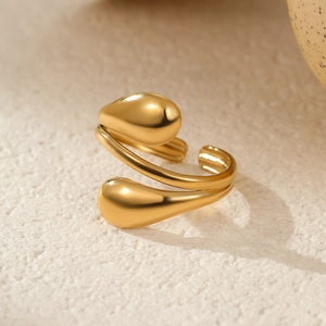 Detail of 18k gold plated stainless steel open ring with teardrop ends on stone surface