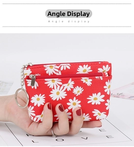 Macro detail of red daisy coin purse with dual zippers and silver metal keychain ring