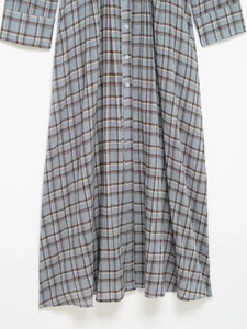 Detail of blue and brown plaid shirt dress fabric with buttoned placket and sleeves