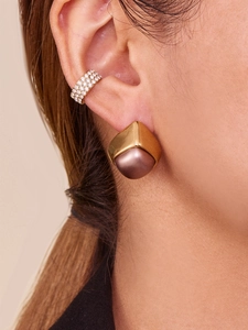 Macro shot of gold geometric earrings with coffee pearl and diamond ear cuff