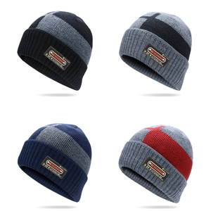 Detail view of four color-blocked knitted winter beanies with classic faux leather patch