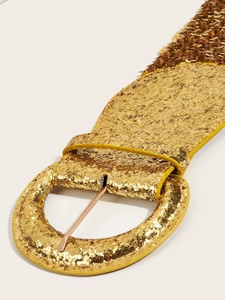 Close-up of a wide golden sequin elastic waist belt with a round buckle for dresses