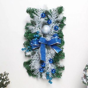 Detail eines Weihnachtskranzes mit blau-silbernen Ornamenten, Tannennadeln und Schleife