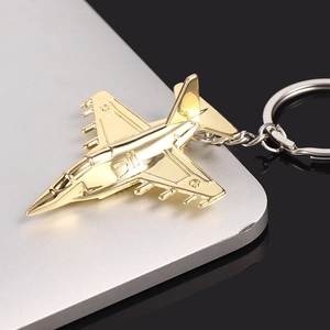 Polished golden airplane model keychain accessory on silver laptop surface