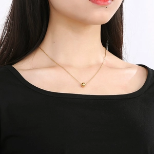 Nahaufnahme einer minimalistischen Goldkugelkette an einem Model in Schwarz
