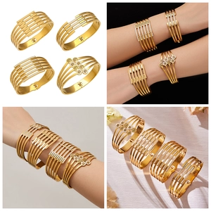 Dettaglio bracciali dorati con motivi albero della vita e cristalli cechi incastonati