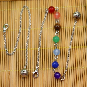 Yoga necklace with 7 colorful beads and hollow silver spheres on a bamboo background