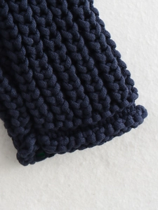 Close-up of dark blue thick knit cardigan texture with detailed scale knit pattern