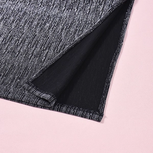 Détail du tissu argenté métallisé avec texture pailletée et fente latérale