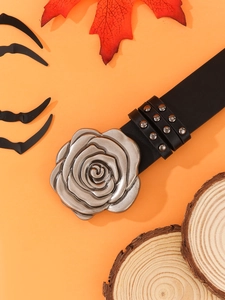 Macro detail of leather belt with punk silver rivets and large vintage rose floral buckle