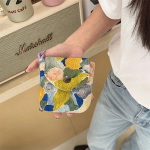 Close-up of portable pouch featuring oil painting texture and vintage metal button clasp