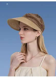 Detail view of woven beige straw brim and brown satin headband on sun visor hat
