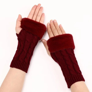Close-up of burgundy knit fingerless gloves with fluffy faux fur trim on hands