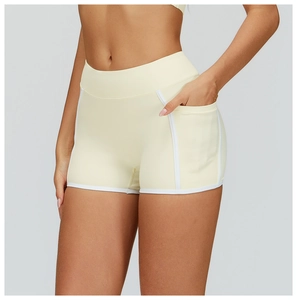 Close-up of yellow yoga shorts with high waist, white contrast trim and side pocket