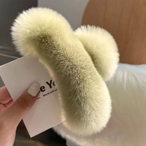 Close-up of soft faux rabbit fur texture on a large light green plush hair claw clip