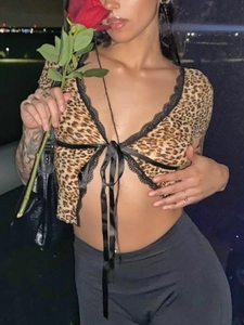 Detail of leopard print crop top featuring black lace trim and ribbon tie-up closure