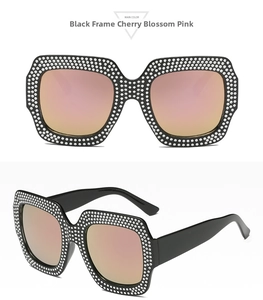Detail of square oversized black frames with rhinestones and cherry pink lenses