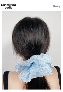 Close-up of light blue striped oversized scrunchie with pleated seersucker texture