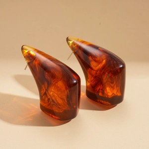 Detail view of amber resin geometric earrings showing translucent smoky texture and luster