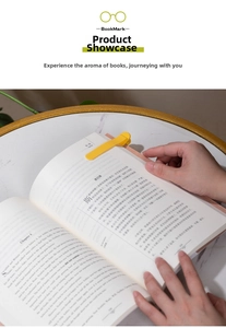 Detail of yellow silicone bookmark clip holding pages on a book over marble table