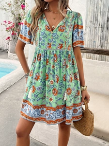 Detail view of V-neck printed dress with button accents and tassel drawstring waist