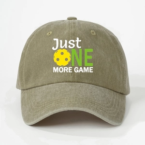 Close-up of khaki washed cotton baseball cap with Just One More Game pickleball print