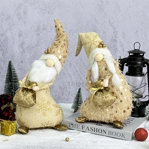 Pair of champagne gold Christmas gnomes with sequins and snowflake hats on faux snow