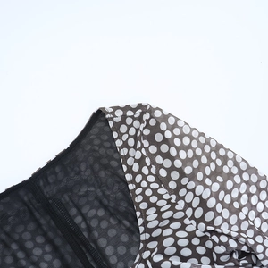 Close-up of brown polka dot mesh fabric with high-quality stitching on a square neck dress