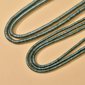 Macro shot of 4mm metallic hematite disc beads with teal luster for DIY jewelry