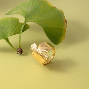 Dettaglio dell'anello a foglia di ginkgo dorato con venature e fascia aperta regolabile