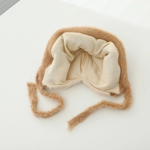 Detailansicht der braunen Wintermütze mit weichem Strickfutter und Bindebändern für Kinder