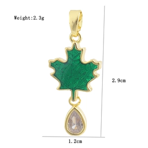 Detail view of a 18K gold plated green maple leaf pendant with a teardrop clear gemstone