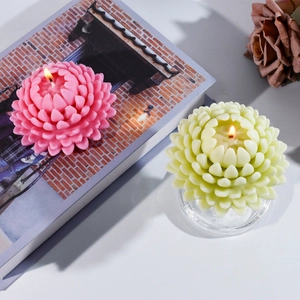 Detailed view of layered flower-shaped scented candles lit in a cozy home setting