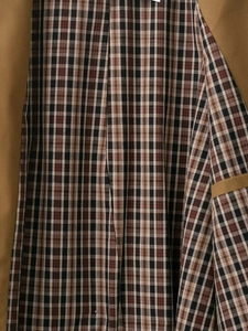 Detail of classic plaid lining and camel brown twill fabric on women trench coat