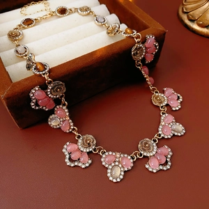 Close-up of vintage gold necklace with flower pendants and tiger eye stones on gift box