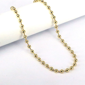 Close-up of polished 3mm gold-plated copper beads on an adjustable geometric chain